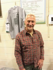 Brother Knight Mike Fennick standing in front of our new Council tee shirt and helping patrons with their purchase.