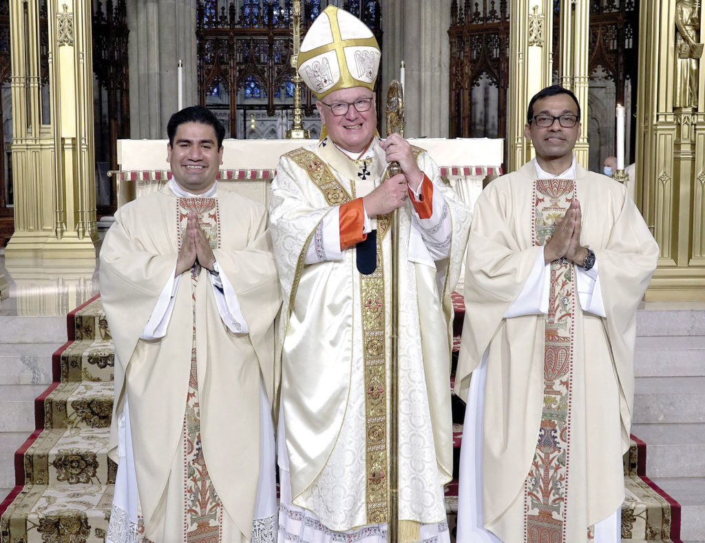 Cardinal Dolan, left, smiles alongside the two new priests he ordained—one for the archdiocese, Father Luis M. Silva Cervantes, left, and the other for the Idente Missionaries, Father Roland P. Pereira, M.Id. The cardinal served as principal celebrant at the Mass of Ordination of Priests June 26 at St. Patrick’s Cathedral. Photo by Chris Sheridan of Catholic NY.